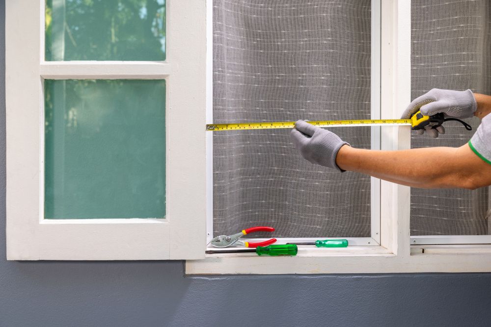 Technician measuring a window opening for accurate replacement window installation